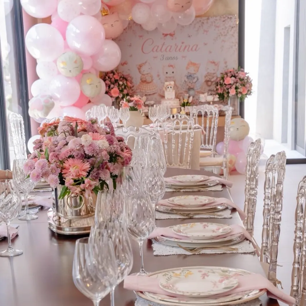 Mesa comprida decorada com flores e taças